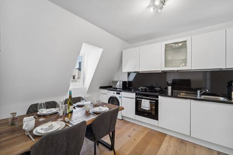 Die moderne Küche mit Essbereich bietet hochwertige Geräte, viel Stauraum und ist ideal für gemeinsame Mahlzeiten ausgestattet.