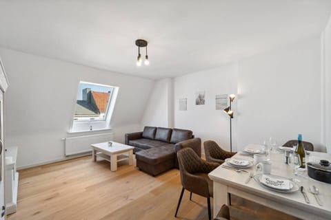 Stilvoller Essplatz mit hellem Holztisch und vier gepolsterten Stühlen.