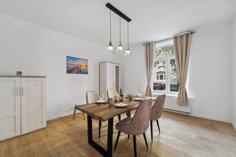 Stilvoll eingerichtetes Esszimmer mit großem Holztisch, bequemen Stühlen und viel Tageslicht.