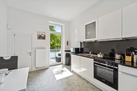 Moderne Einbauküche mit kompletter Ausstattung und Zugang zum Balkon.