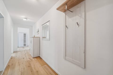 Heller, einladender Flur mit Garderobe, Spiegel und viel Stauraum.