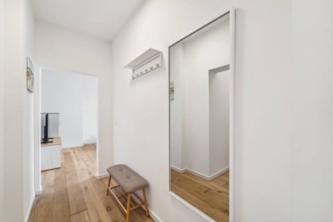 Heller Eingangsbereich mit Spiegel und Sitzbank – praktisch und einladend gestaltet.