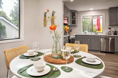 Set the table and enjoy a cozy meal with loved ones. The thoughtful table setting and simple floral centerpiece make for a delightful dining experience.