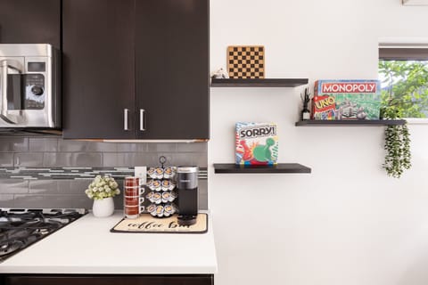 Enjoy classic board games like Monopoly, Uno, and Sorry on stylish floating shelves. Start your mornings with a fresh cup of coffee from the Keurig station.