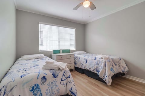 Second floor bedroom with two single beds, central A/C, closet and ceiling fan.