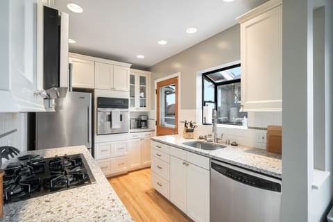 MAIN FLOOR - KITCHEN: The functional and stylish kitchen is designed to make cooking a pleasure. It features a spacious refrigerator, built-in oven, gas cooktop, microwave, and dishwasher.
