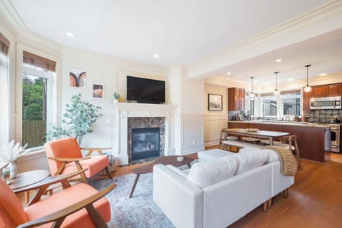 Main Floor - Living Room: A seamless integration of comfort and style, flowing effortlessly into the kitchen and dining area. A solid wood table with benches and chairs adds a touch of rustic charm while maintaining functionality.