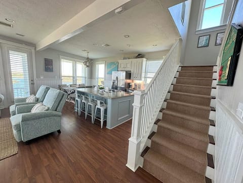 View of living, dining, kitchen, and stairs from entryway.
