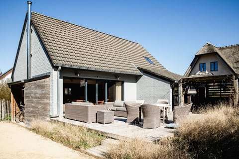 Exterior view of the villa and garden with outdoor seating