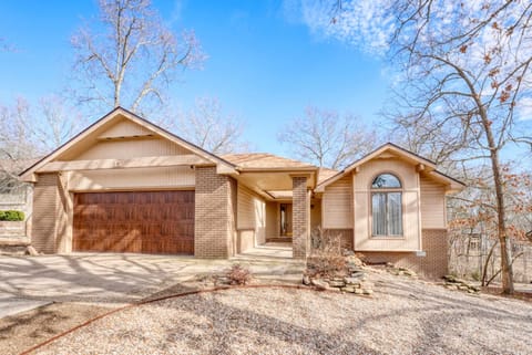 Inviting front exterior with two-car garage & mature trees—welcome to your Bella Vista retreat.