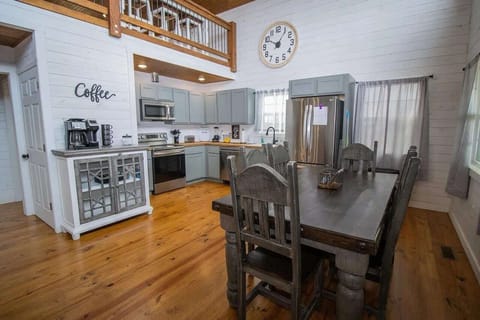Fully stocked kitchen with Keurig and drip coffee makers, spices, blender, dishwasher, and a farmhouse table seating eight.