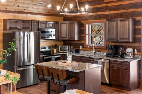 Fully equipped chef’s kitchen with granite countertops and bar seating.