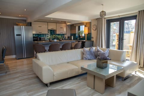 Lounge area with large sofa and doors leading to the patio area