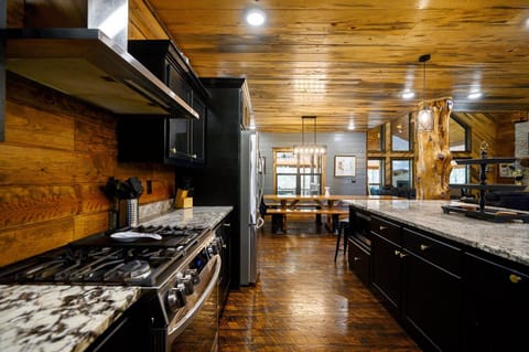 Rustic charm meets modern amenities in this cozy cabin kitchen, complete with sleek appliances and warm wood finishes—perfect for your culinary adventures.