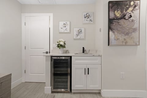 A beautifully designed wet bar with a built-in wine cooler, sleek cabinetry, and artistic accents, perfect for entertaining or enjoying a quiet drink.