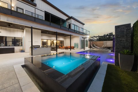 Backyard oasis with infinity edge hot tub and stunning pool.