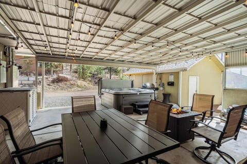 Welcome to Mountain Villa! This spacious covered patio invites you to unwind with a hot tub, cozy seating, and a dining area—perfect for enjoying the fresh mountain air in comfort.