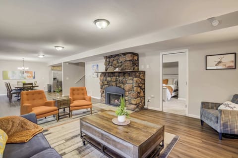 The cozy living area features a rustic stone fireplace, warm lighting, and stylish furnishings—perfect for relaxing after a day of mountain adventures.