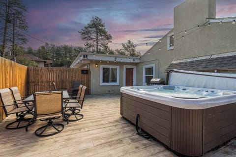 Welcome to Mountain Retreat! Unwind in your private outdoor oasis featuring a bubbling hot tub, dining space, and string lights for cozy evenings under the stars.