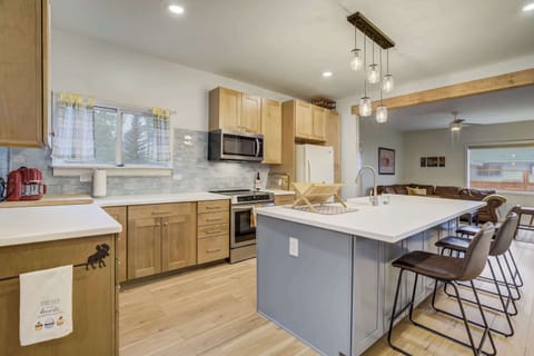 Modern kitchen with style and function – featuring stainless steel appliances, light wood cabinetry, and a spacious island with bar seating. Pendant lighting adds a warm touch, making this the perfect space for cooking and gathering.