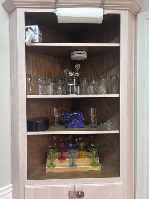 Bar area with margarita glasses, wine glasses and cocktail accessories.