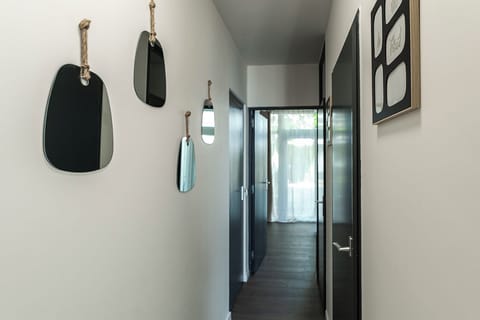 A bright and stylish hallway with playful mirrors leading to a cozy retreat.