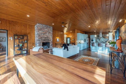 Open-concept living room with gas log fireplace and dining area for 8