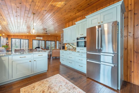 Kitchen with gas range, double oven, dishwasher, drip-style coffee maker, and breakfast bar seating for 3