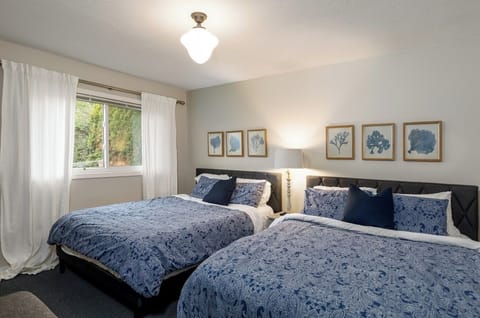 Large bedroom with 2 queen beds (sleeps 4) across from the full bathroom.