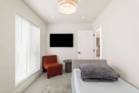 Compact & cozy retreat! Enjoy our snug space with a comfy daybed and a vibrant orange chair. Relax with a movie on the flat-screen TV. Perfect for solo travelers seeking a peaceful getaway. Unwind and make yourself at home in this stylish nook!