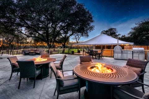 Spacious patio with firepits, string lights, and a full outdoor kitchen – perfect for relaxing or entertaining under the stars!