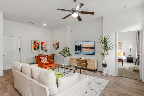 Modern living room features a sectional queen sized sofa bed, 65"smart TV & more