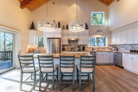 Large kitchen features an island with barstool seating.