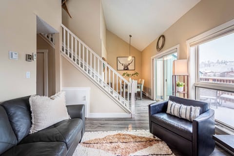 Bright open living and dining area over looking Fraser River and mountains