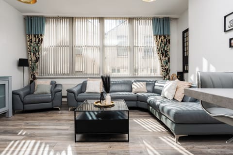 The comfortable living space features a large open-plan lounge and kitchen, Smart TV with Netflix, and spacious seating—ideal for relaxing after a day in the city.
