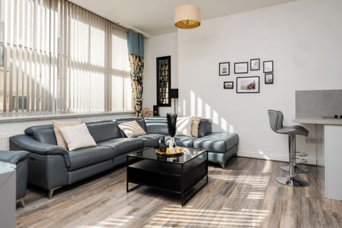 The comfortable living space features a large open-plan lounge and kitchen, Smart TV with Netflix, and spacious seating—ideal for relaxing after a day in the city.
