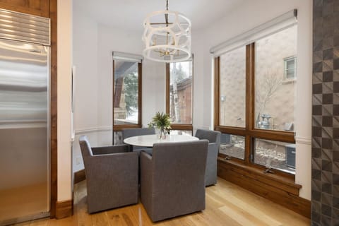 Quiet breakfast nook with round table, modern chairs, and large windows.