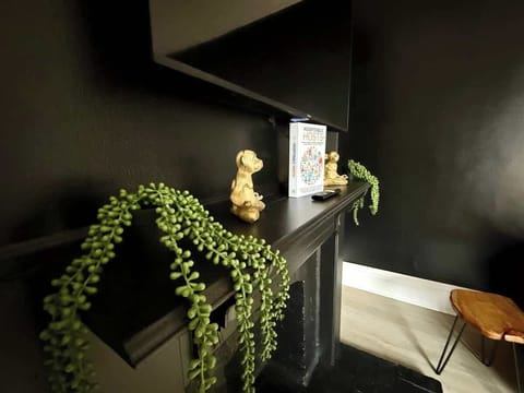 Host memorable gatherings in our stylish dining area at Jungle House Airbnb, featuring a sleek wooden table, vibrant yellow chairs, and a lush green accent wall The perfect blend of modern elegance and cozy charm in Short North Columbus