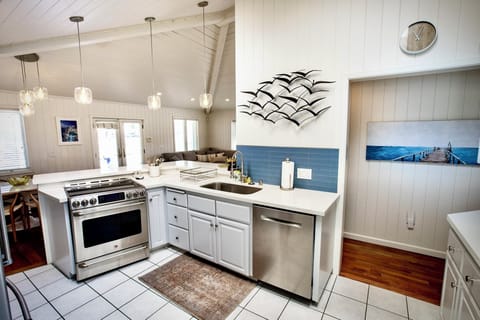 Bright, airy, and fully equipped, this kitchen is the heart of the home. Featuring vaulted ceilings with skylights, sleek pendant lighting.