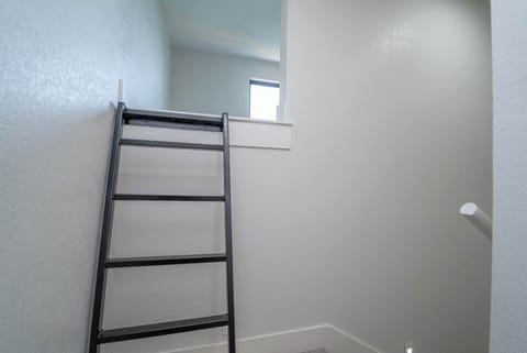 Architectural detail. The interplay of light and shadow, the subtle textures of the walls, and the simple elegance of the ladder.