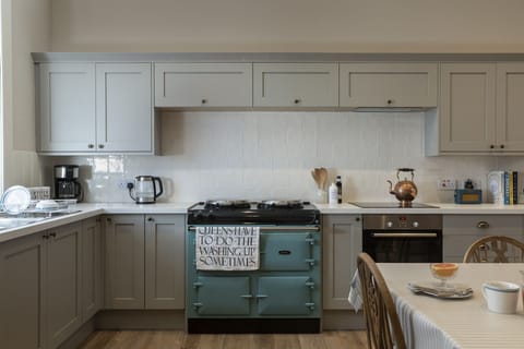 New Ladykirk Farmhouse - the AGA and blue cabinets in the open-plan farmhouse kitchen