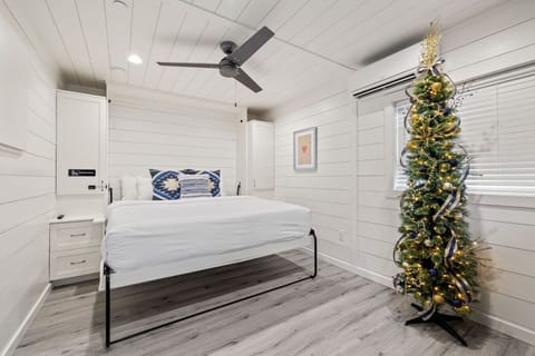 Bright and modern bedroom with a cozy queen bed and festive Christmas décor.
