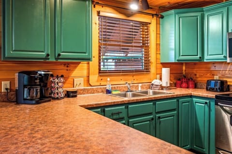 Kitchen: Vibrant teal cabinets and modern amenities make cooking a delight in this charming space!