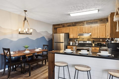 Cook, brew, and savor the flavors of home in our well-stocked kitchen. Dining table can be pulled away from the wall to reveal two benched and two dining chairs.
