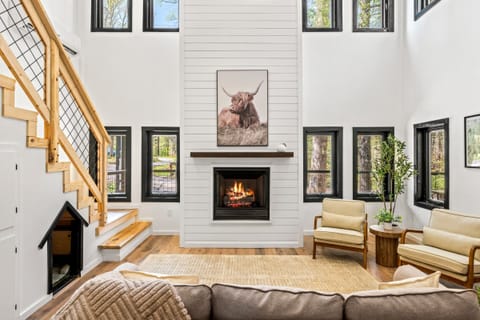 Bask in natural light beside the fireplace, surrounded by modern charm and peaceful natural views.