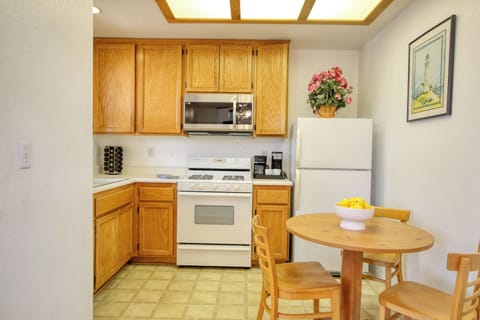 This modern kitchen features oak cabinets for storage, a gas stove and a cozy dining nook for three.