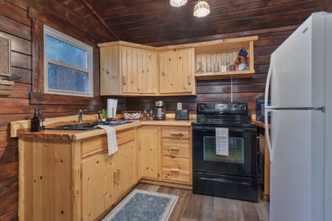 Cook up comfort in this charming cabin kitchen 🍳🌲 With rustic wood cabinetry, full appliances, and all the essentials, you’ll have everything you need for a hearty meal or a cozy coffee break ☕🍽️