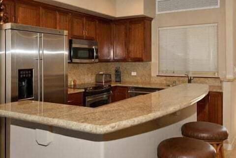 Cook with ease in this modern kitchen featuring stainless steel appliances and a spacious breakfast bar.