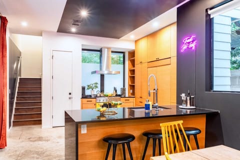 Fully Equipped Kitchen With Spacious Countertops And An Island With High Chairs For Dining