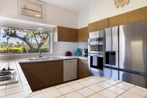 Start your mornings right with coffee in hand and serene greenery framed through the kitchen window.
